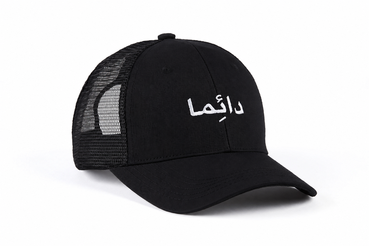 Casquette trucker noire avec broderie arabe blanche « دائماً »