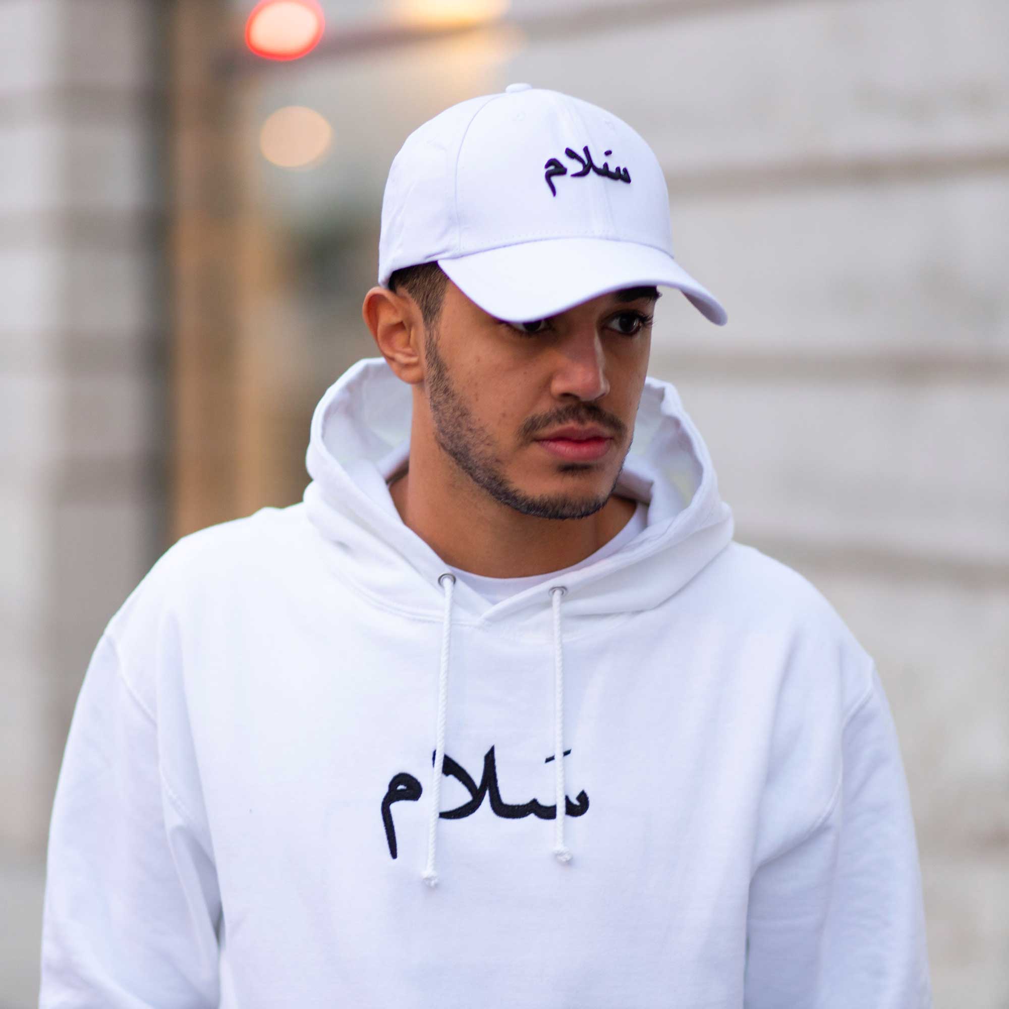 Sweat et casquette blanche de la marque kalam clothing avec écriture arabe salam noire